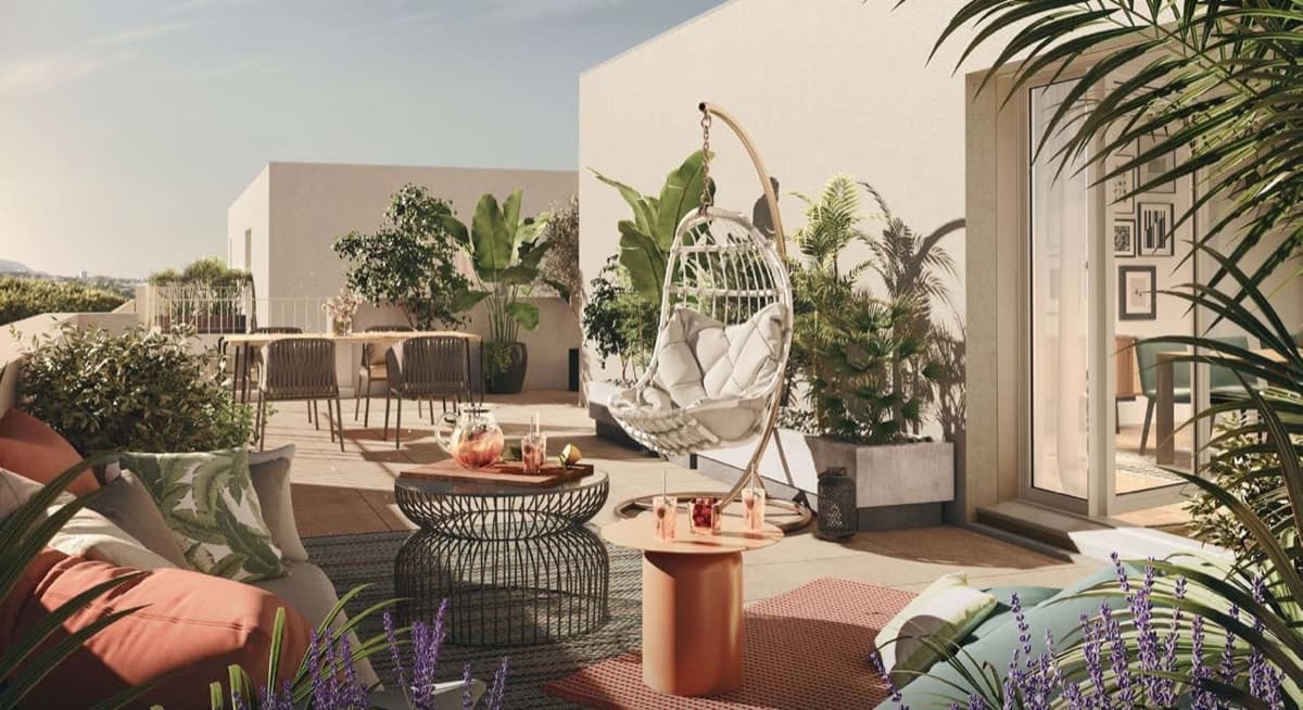 Terrasse ensoleillée d'un appartement neuf: fauteuil suspendu, plantes méditerranéennes et lavande au premier plan.